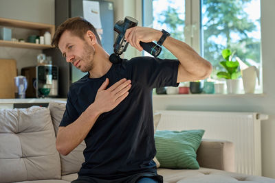 Side view of young man exercising at home