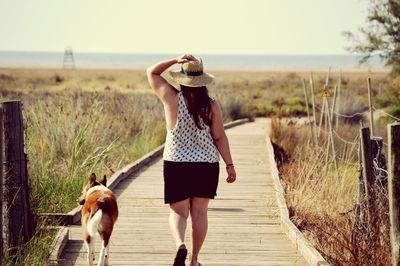 Rear view of woman walking on road