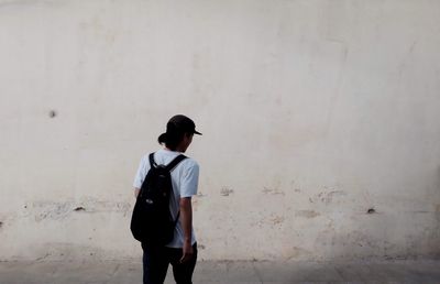 Full length of woman standing against wall