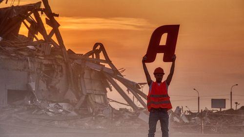 Man with a on the background of a destroyed building