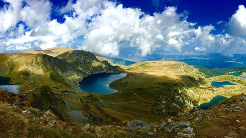 Scenic view of lakes by mountains against cloudy sky