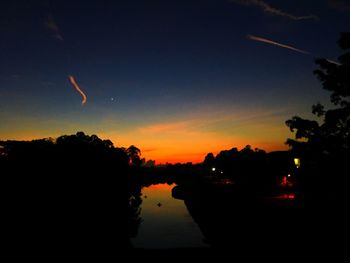 Silhouette trees against sky at night