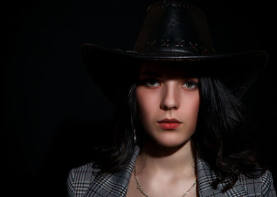 Portrait of a beautiful young woman over black background