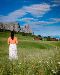 Rear view of woman on field against sky