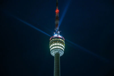 Stuttgart television tower against night sky with stars and light beams, germany