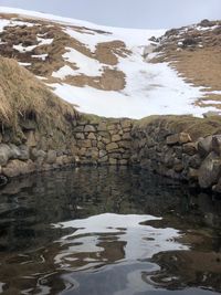 Reflection of rocks in lake against sky