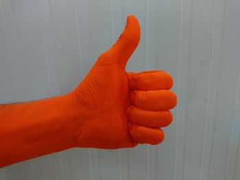Cropped image of orange hand gesturing thumbs up