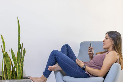 Woman sitting on sofa at home