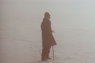 Side view of silhouette woman walking on beach