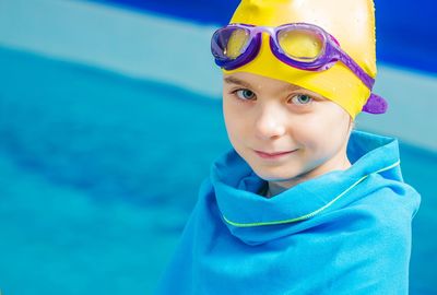 Portrait of smiling boy wearing swimming goggles and cap