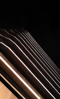 Low angle view of illuminated bridge against sky at night