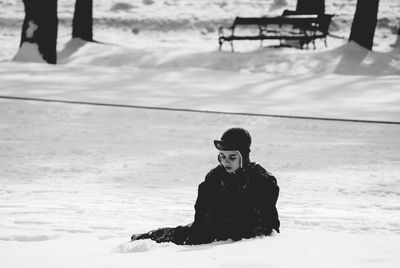 Full length of boy tobogganing on snow