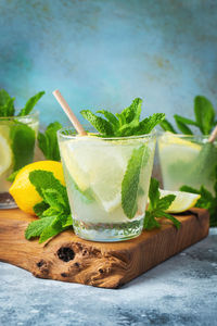 Two glass with lemonade or mojito cocktail with lemon and mint, cold refreshing drink.