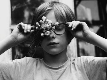 Close-up of cute boy wearing eyeglasses while holding flower