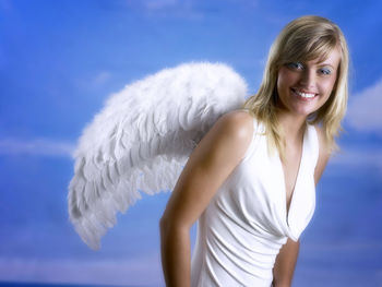 Portrait of beautiful young woman wearing angel wings