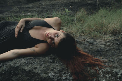 High angle portrait of woman lying on land