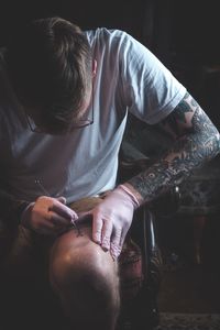 Midsection of man holding while sitting in kitchen