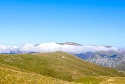 Scenic view of snowcapped mountains against blue sky