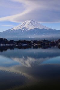 Scenic view of lake by snowcapped mountains against sky