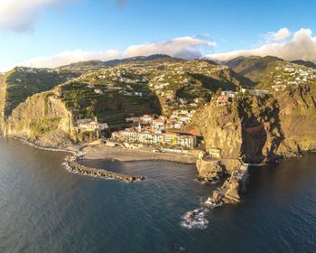 High angle view of buildings by sea against sky