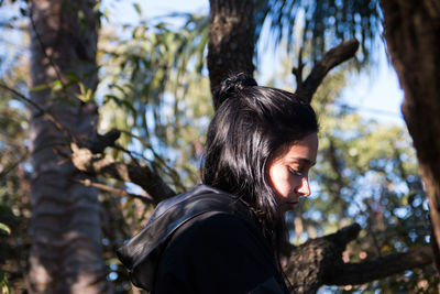 Beautiful woman standing against palm trees