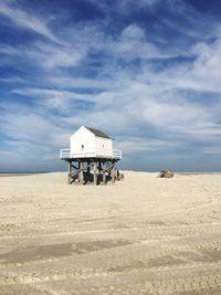 Lifeguard hut on desert against sky