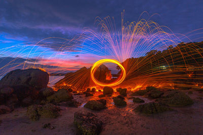 Light painting on rock against sky at night