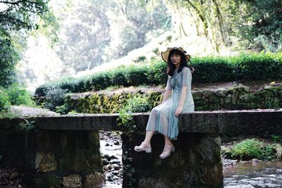 Woman wearing hat against trees