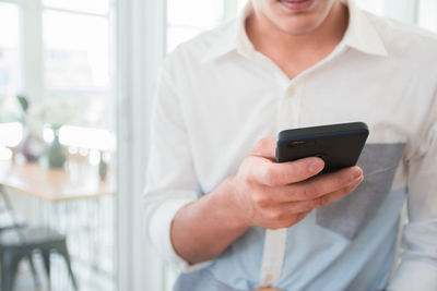 Midsection of man using mobile phone