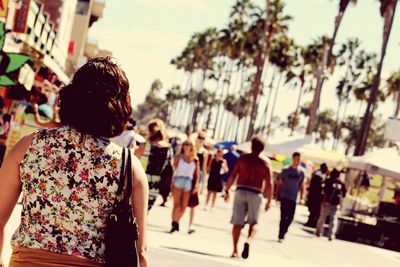 Rear view of women with people in background