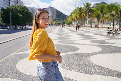 Copacabana stylish woman walking on famous promenade in rio de janeiro, brazil
