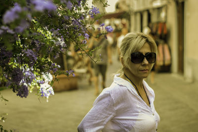 Portrait of woman with sunglasses against plants