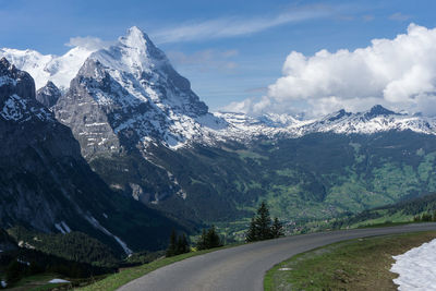 Road amidst snowcapped mountains against sky