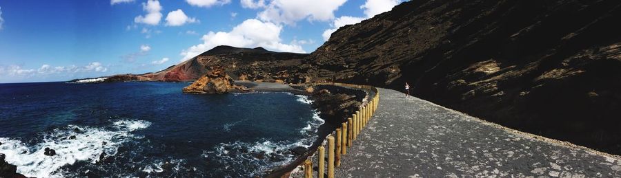 Panoramic view of sea and mountains against sky