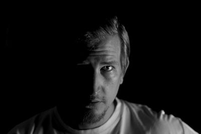 Portrait of man against black background