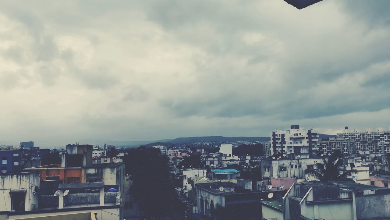 VIEW OF CITYSCAPE AGAINST CLOUDY SKY