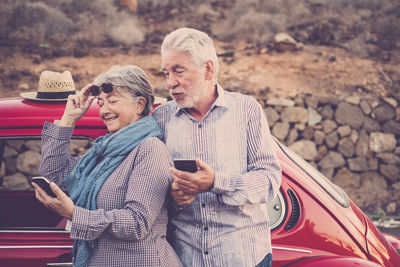 Rear view of man and woman using mobile phone