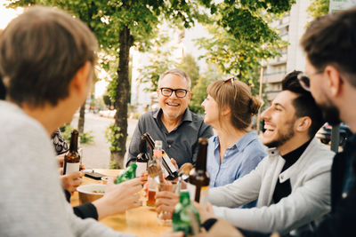 Portrait of happy mature male sitting with friends and enjoying at social gathering