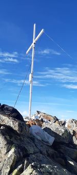 Windmill on rock against blue sky