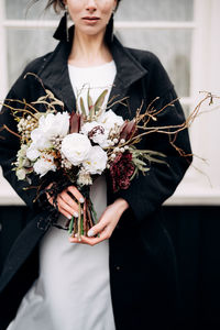 Midsection of woman holding flower bouquet