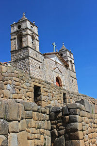 Low angle view of historical building against clear blue sky