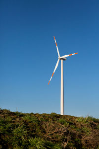 Low angle view of windmill on field against clear sky