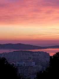 High angle view of silhouette buildings against sky during sunset