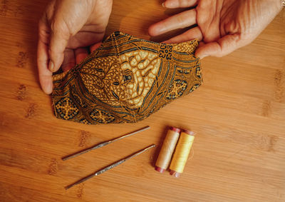 High angle view of person holding bread on table