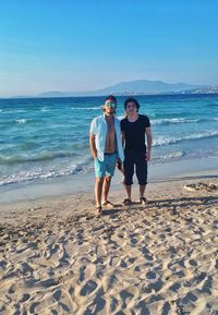 Full length portrait of young man standing on beach