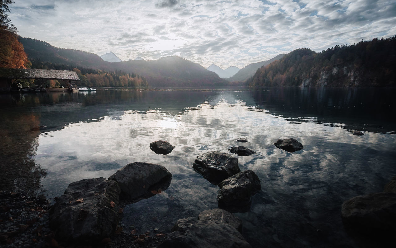 ROCKS BY LAKE AGAINST SKY