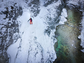 High angle view of man walking on snow covered snowcapped mountain