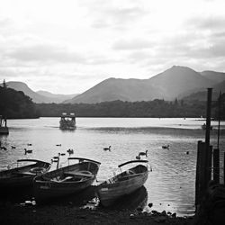 Boats in sea with mountains in background