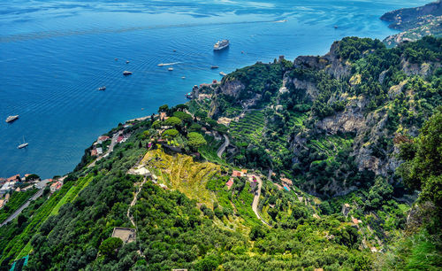 High angle view of sea by trees on cliff