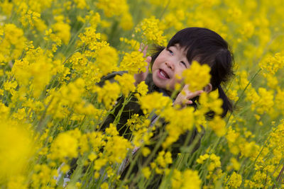 Portrait of smiling young woman on yellow flowering field